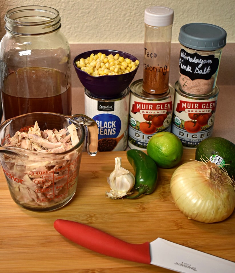 all the ingredients lined up on a cutting board to make black bean and chicken soup