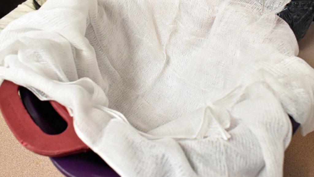 cheese cloth lined colander resting in a bowl