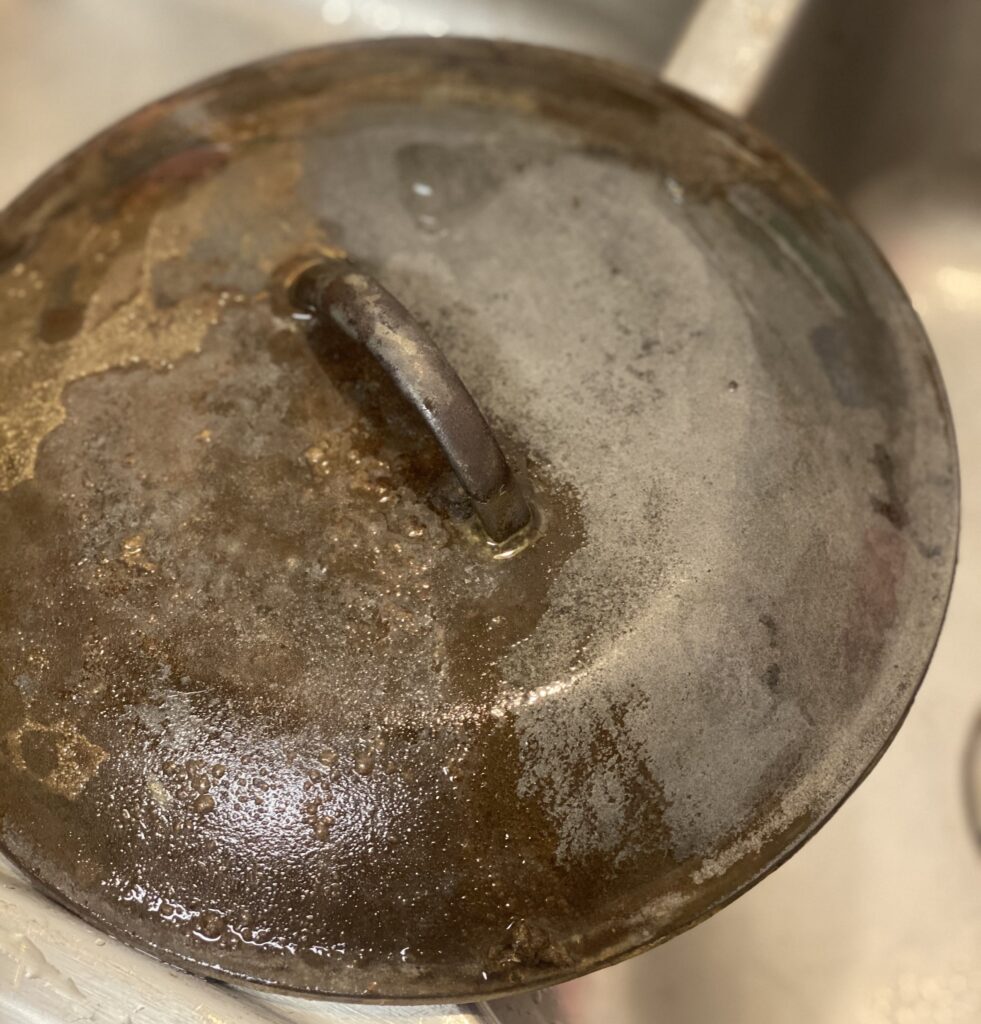 a partially cleaned vintage cast iron lid