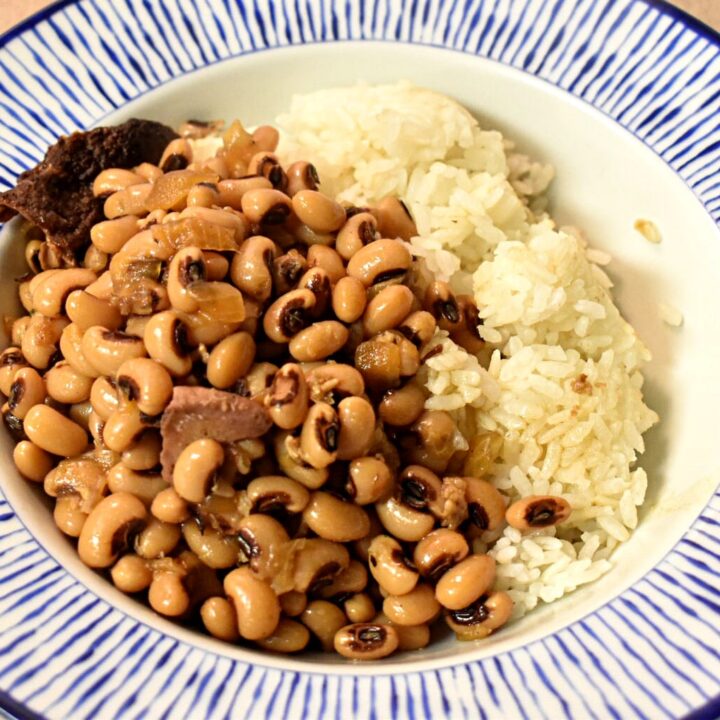 black eyed peas over white rice in a blue and white bowl
