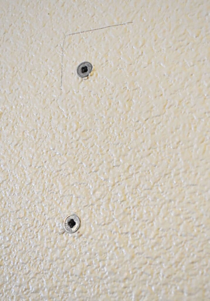 two sheet rock anchors in the wall
