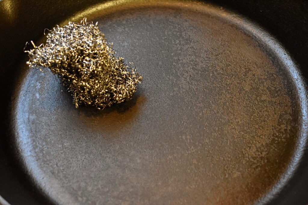 a cast iron skillet with steel wool resting inside