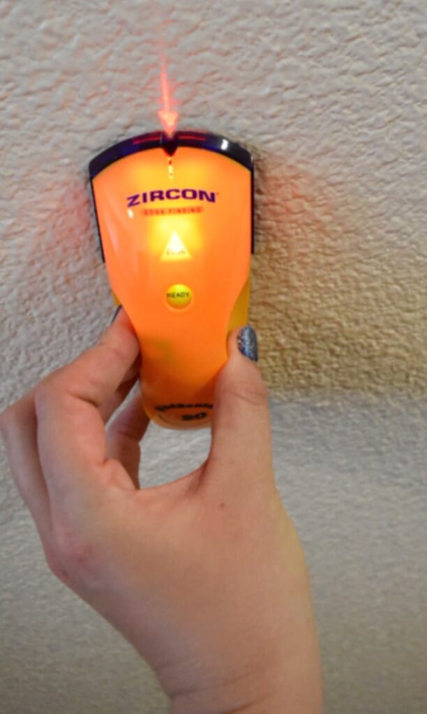 a stud finder lit up on the wall