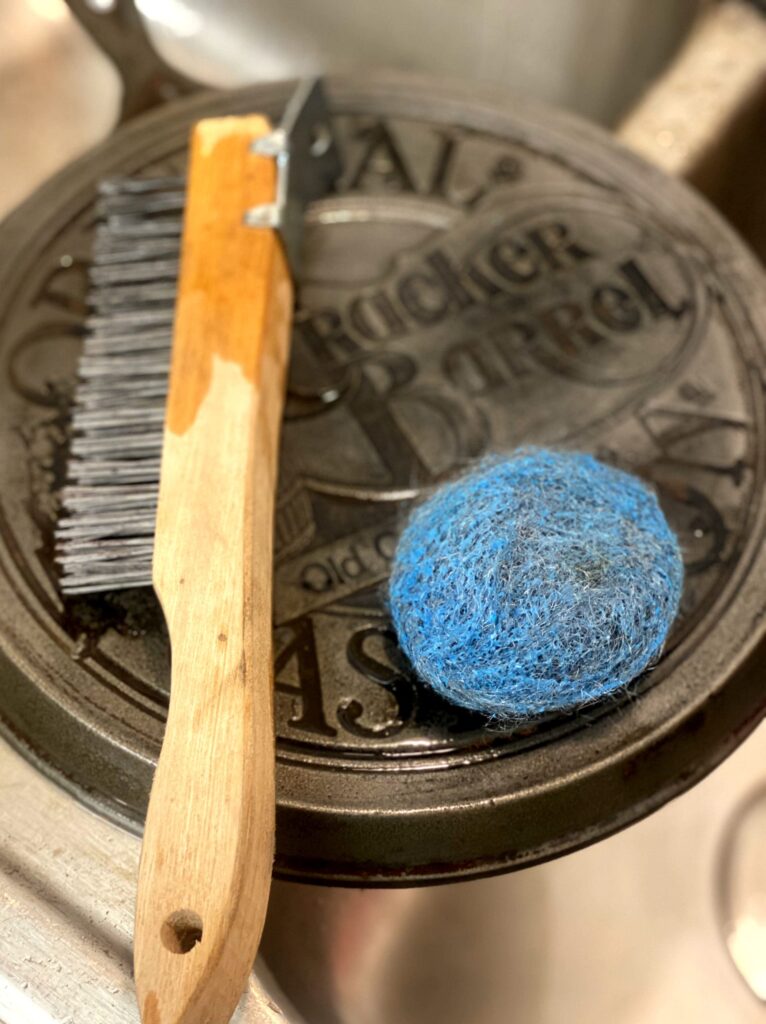 steel wool and a metal bristle brush on a cast iron skillet