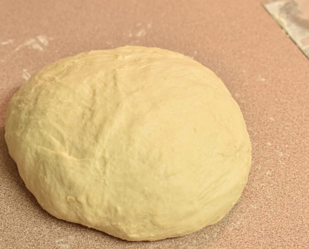 tasty rustic sourdough loaf kneaded and resting on countertop