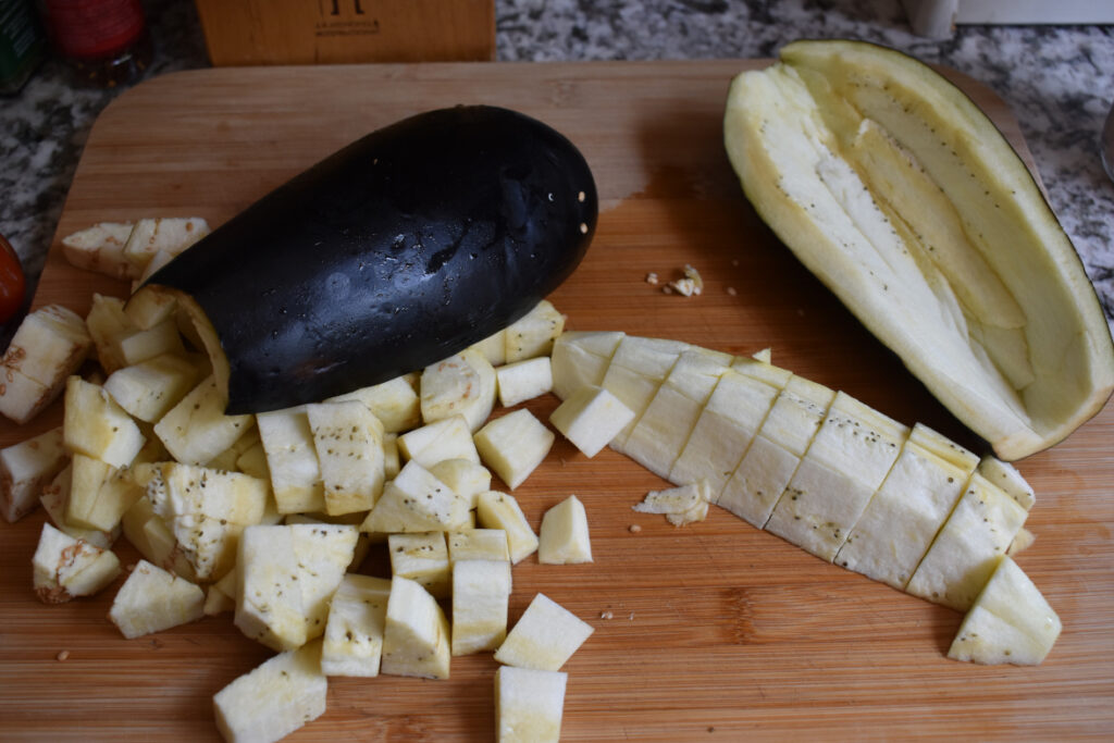 eggplant cubed and hollowed out on cutting board