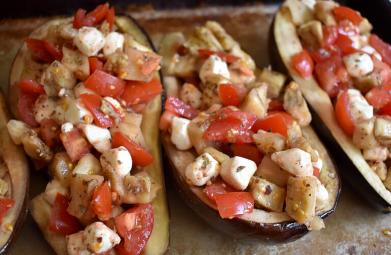 two stuffed simple eggplants on a baking tray ready to be roasted